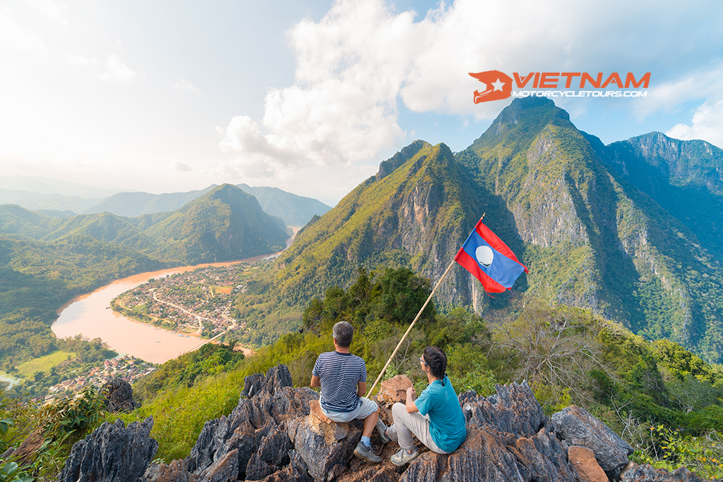 couple conquering mountain top nong khiaw panoramic view nam ou river valley laos national flag scenic mountain landscape 1